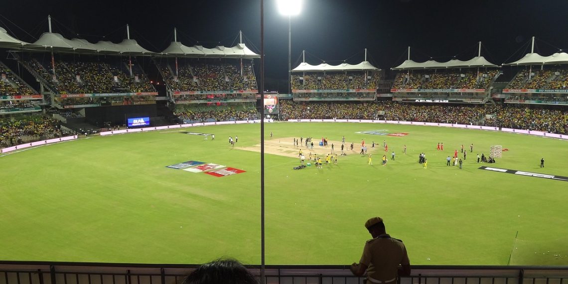 Cricket stadium under floodlights during a night match
