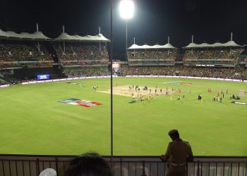 Cricket stadium under floodlights during a night match