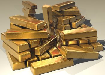 Gold bars resting on moss on a forest floor