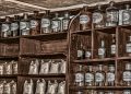Tins of food and bottles of water stacked on a kitchen shelf