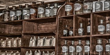 Tins of food and bottles of water stacked on a kitchen shelf